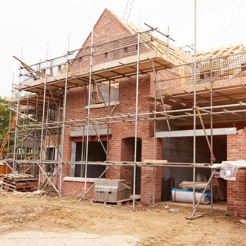 Brick home under construction with scaffolding around it
