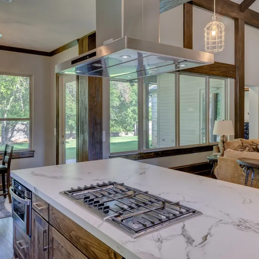 Remodeled kitchen with a marble island and gas cooktop