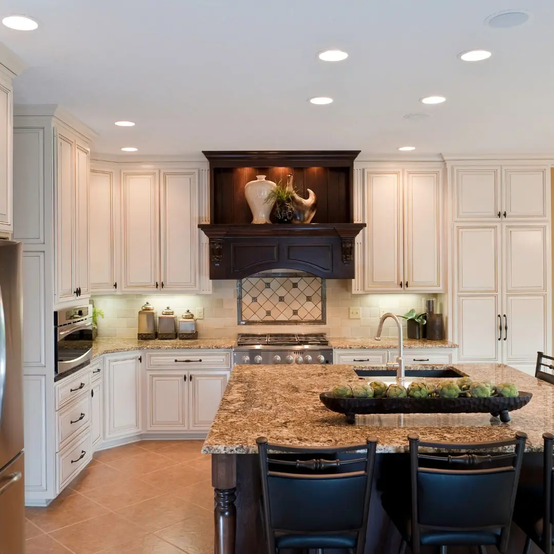 Finished kitchen with cream cabinets and a granite island