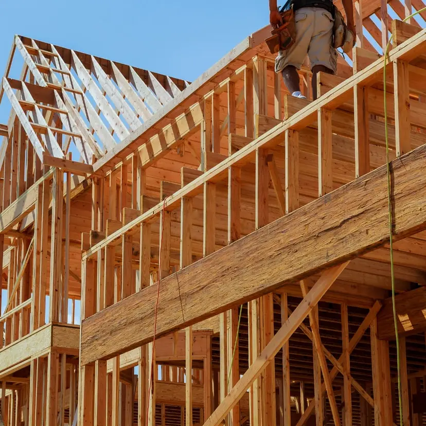 Wood wall and roof framing of a new home against a blue sky