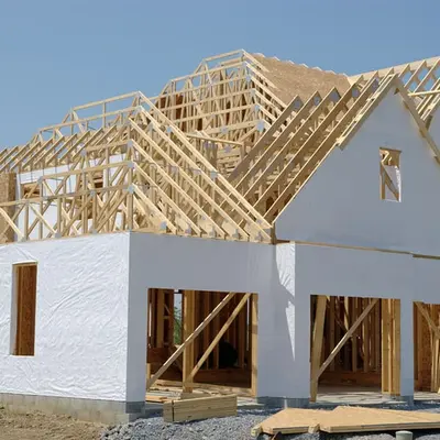 Framed home addition covered in house wrap with roof trusses in place