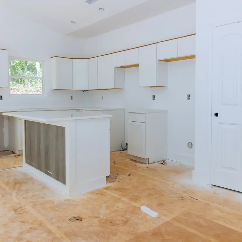 New white cabinets and island being installed during a home remodel