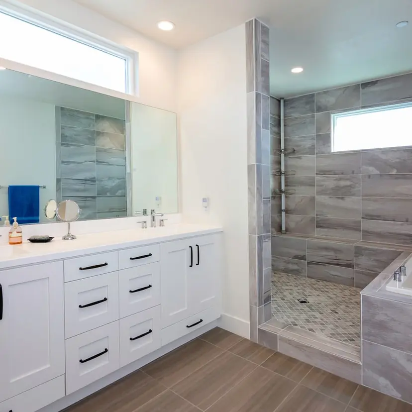 Updated rental bathroom with a white vanity and a new tile shower