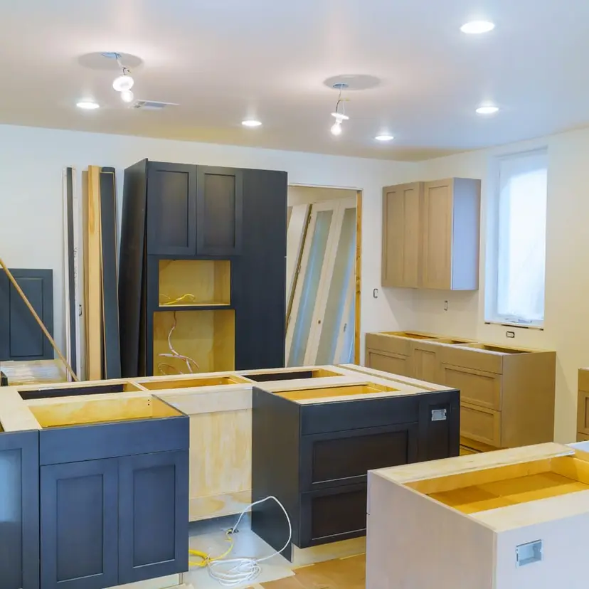 Dark and natural wood kitchen cabinets partway through installation