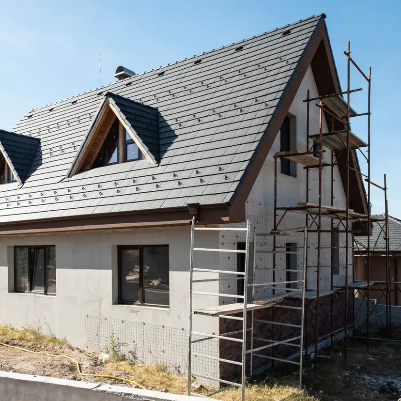 Steep-roofed house with scaffolding during exterior work in the Slidell area
