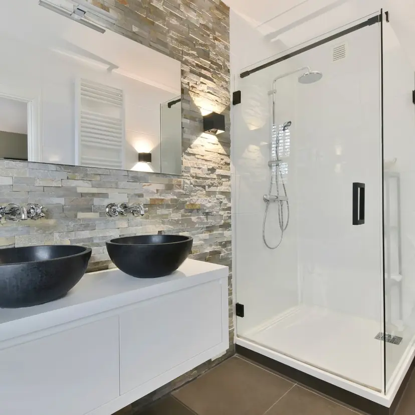 Finished bathroom with a modern double vanity and a glass shower