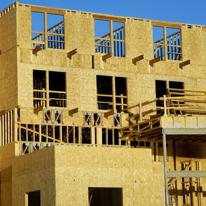 Three-story framed building with wall sheathing going up on a job site