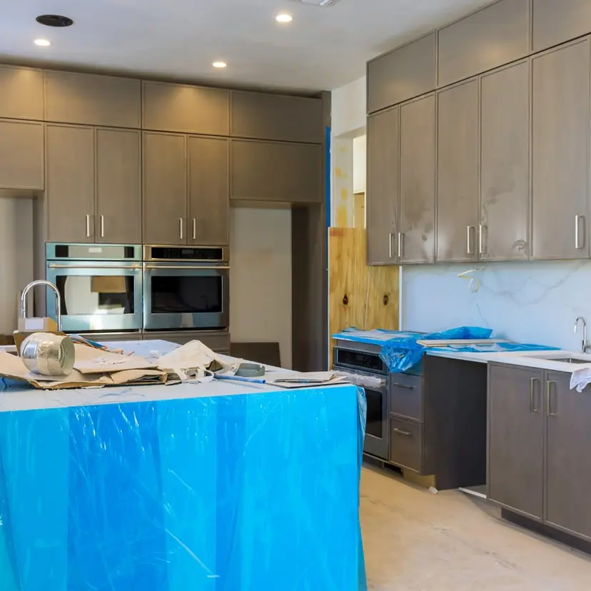 Kitchen under renovation with countertops covered in protective plastic