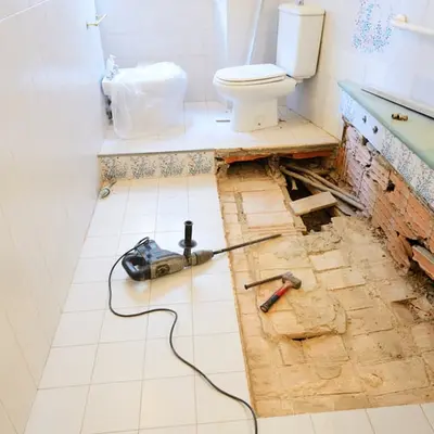 Bathroom floor opened up to show a water-damaged subfloor
