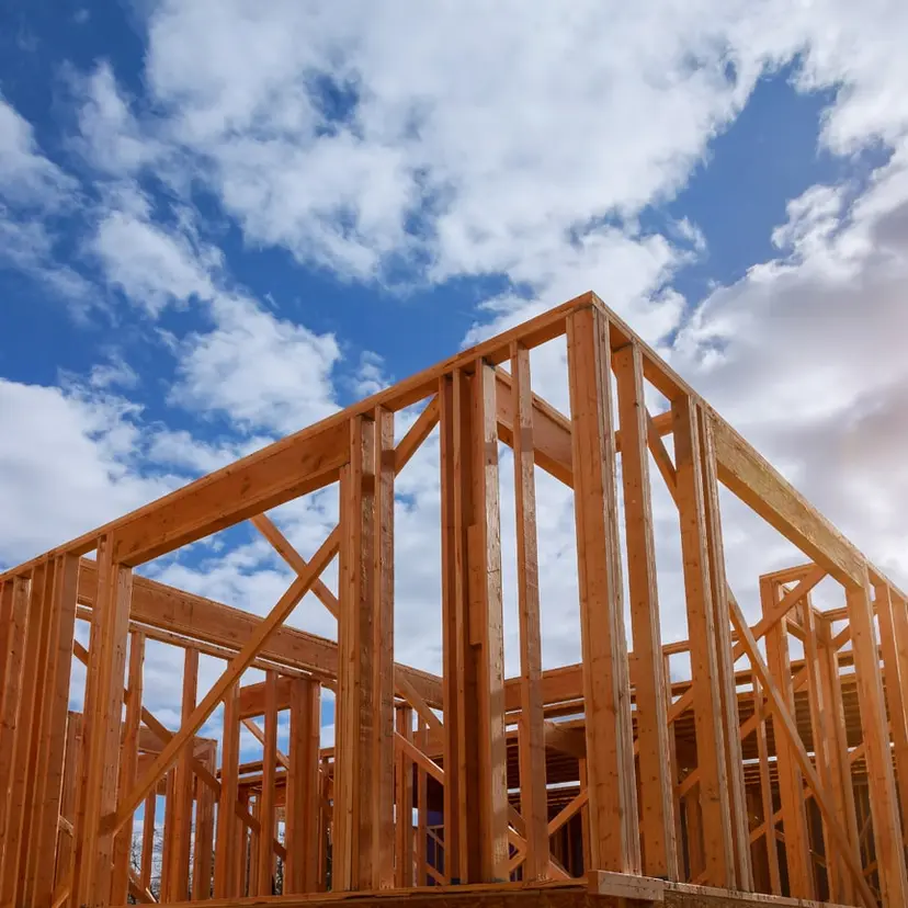 Wood wall framing standing against a cloudy blue sky
